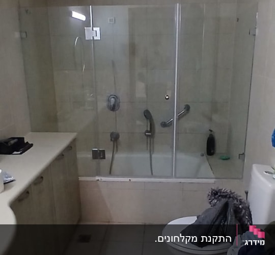 אמבטיון זכוכית מותקן מעל אמבטיה בחדר רחצה